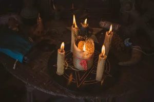 Two gold rings on a velvet cloth beside a love potion bottle.