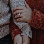 A couple holding hands with a love magic ring.