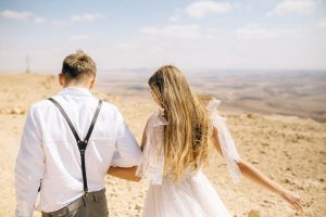 Couple holding hands in the Nevada desert under magical twilight sky