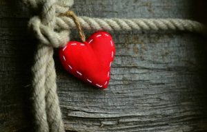 Two intertwined hearts glowing with golden thread