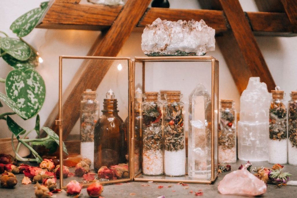 Traditional love spell ingredients including herbs, candles and crystals arranged on a spiritual altar.